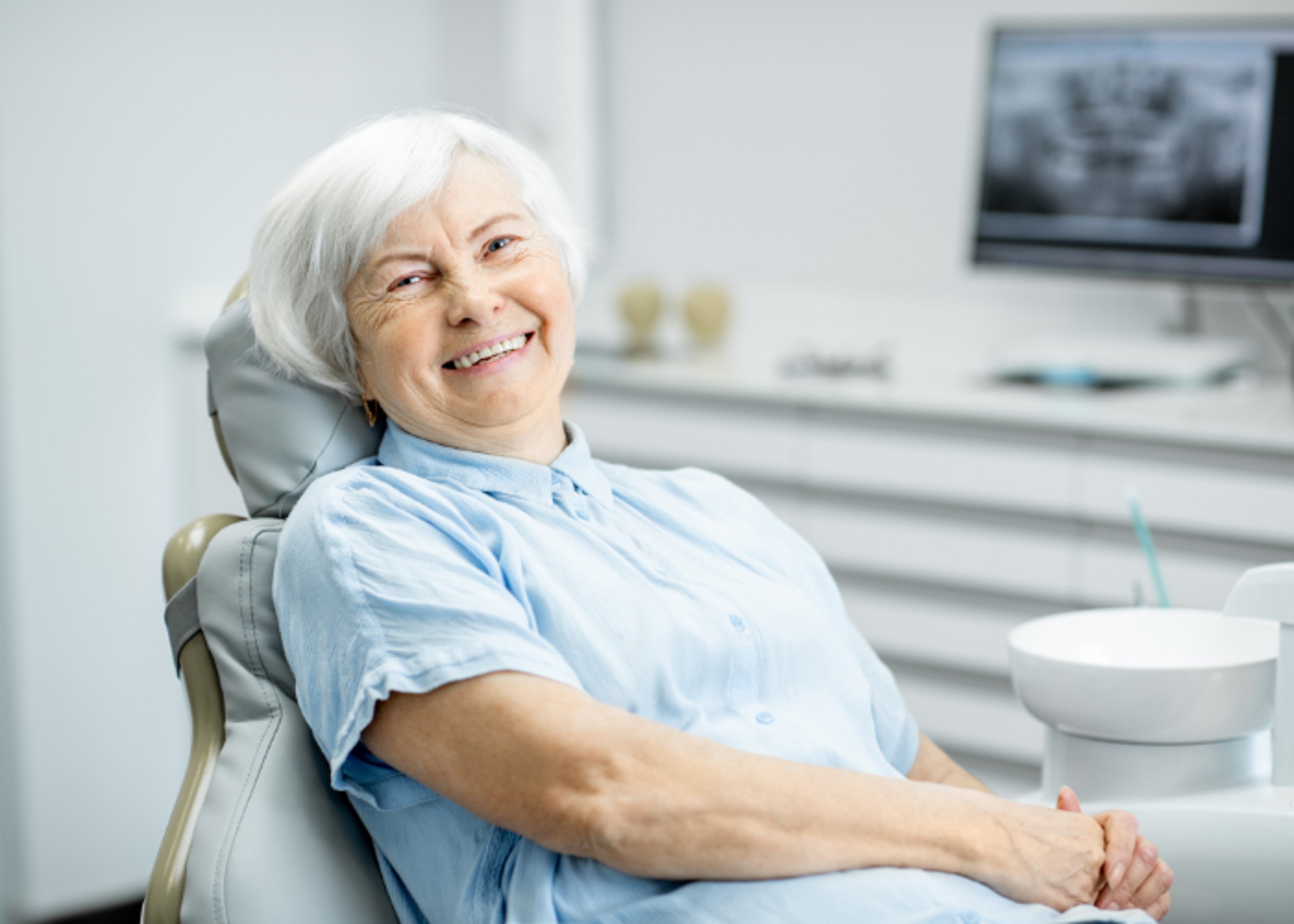 Patientin im Behandlungszimmer, entspannt und lächelnd
